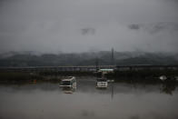 Two vehicles are submerged in floodwaters Monday, Oct. 14, 2019, in Hoyasu, Japan. Rescue crews in Japan dug through mudslides and searched near swollen rivers Monday as they looked for those missing from a typhoon that left as many as 36 dead and caused serious damage in central and northern Japan. (AP Photo/Jae C. Hong)