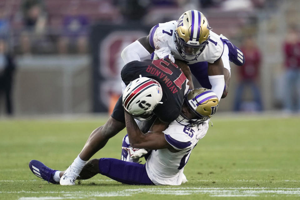 Stanford wide receiver Elic Ayomanor, middle, is tackled by Washington cornerback Dominique Hampton (7) and cornerback Elijah Jackson (25) during the first half of an NCAA college football game in Stanford, Calif., Saturday, Oct. 28, 2023. (AP Photo/Jeff Chiu)