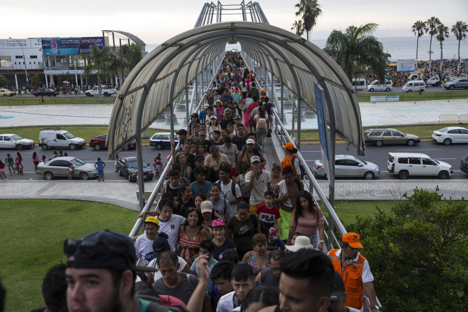 En esta imagen, tomada el 16 de febrero de 2020, los bañistas cruzan un puente peatonal hacia la playa de Agua Dulce, en Lima, Perú. Hasta mediados del siglo XX, las clases bajas de Lima no podían permitirse ir a la playa, dijo Juan Pacheco, historiador de la ciudad. La construcción de carreteras hasta la costa solventó el problema. (AP Foto/Rodrigo Abd)