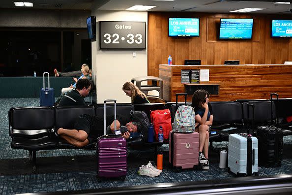 Passengers try to rest and sleep while waiting for delayed and canceled flights off the island as thousands of passengers were stranded at the Kahului Airport (OGG) in the aftermath of wildfires in western Maui in Kahului, Hawaii on August 9, 2023. The death toll from a wildfire that turned a historic Hawaiian town to ashes has risen to 36 people, officials said on August 9. (Photo by Patrick T. Fallon / AFP) (Photo by PATRICK T. FALLON/AFP via Getty Images)