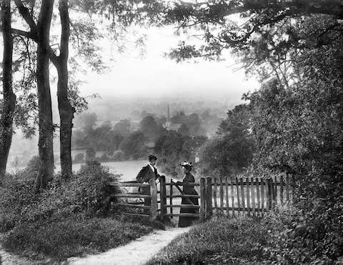 A couple in the Cotswolds negotiate a kissing gate - Credit: Historic England Archive/Heritage Images