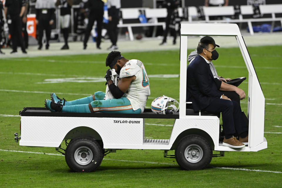 Miami Dolphins outside linebacker Elandon Roberts (44) is driven off the field after an injury against the Las Vegas Raiders during the second half of an NFL football game, Saturday, Dec. 26, 2020, in Las Vegas. Hamstring pulls, ligament tears and ankle sprains can be as formidable an opponent for NFL teams as a high-scoring offense or stingy defense. (AP Photo/David Becker)