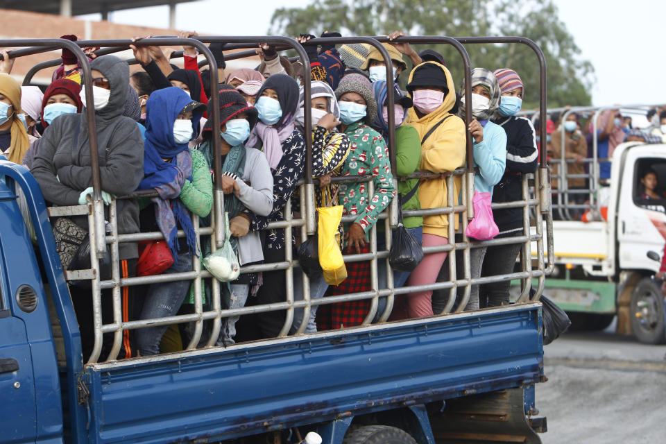 Garment workers stand on the trucks as they head to work outside Phnom Penh, Cambodia, Thursday, May 6, 2021. Cambodia on Thursday ended a lockdown in the capital region. (AP Photo/Heng Sinith)
