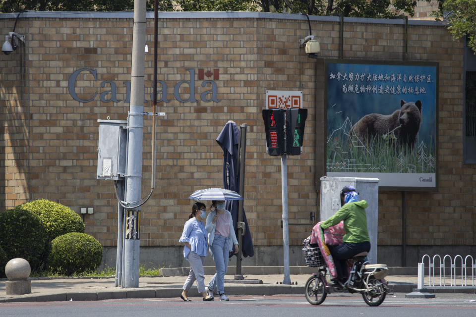 Residents pass by the Canadian Embassy in Beijing on Friday, June 19, 2020. Chinese prosecutors charged two detained Canadians with spying Friday in an apparent bid to step up pressure on Canada to drop a U.S. extradition request for a Huawei executive under house arrest in Vancouver. (AP Photo/Ng Han Guan)