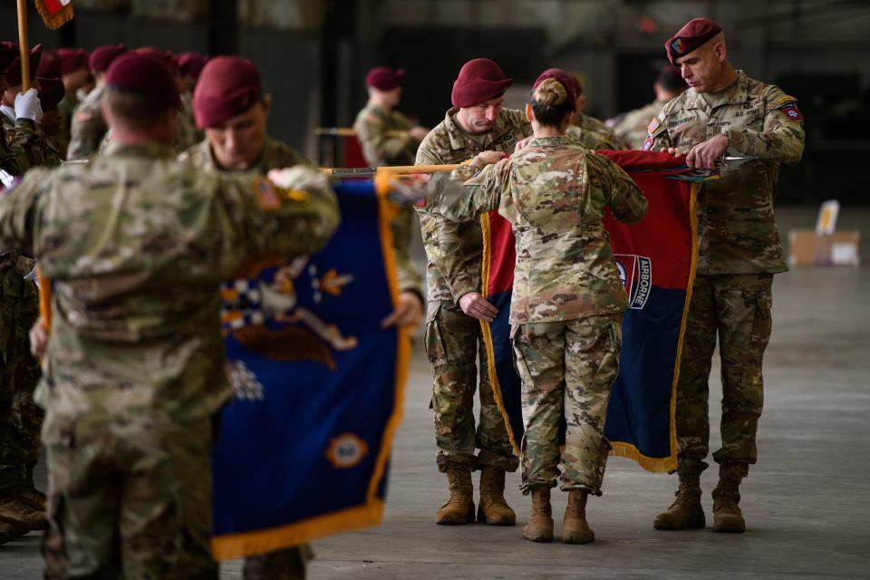 Command Sgt. Maj. James Journigan, left to right, Col. Kirsten Schwenn and Chief Warrant 5 Timothy Shrewsbury roll up the 82nd Combat Aviation Brigade colors during a casing ceremony on Friday, Dec. 1, 2023, ahead of its deployment to the Middle East.