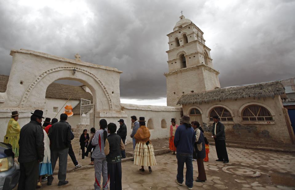 People wait for the newlyweds outside the Sistine Chapel of Los Andes in Curahuara de Carangas, Oruro department, 260 km. (160 miles) south from La Paz, Bolivia, Saturday, Dec. 8, 2012. The colonial-era house of worship known in Bolivia as the Sistine Chapel of the Andes was filled with flowers over the weekend for those celebrating two weddings and seven baptisms on the wind swept mountain plateau. (AP Photo/Juan Karita)