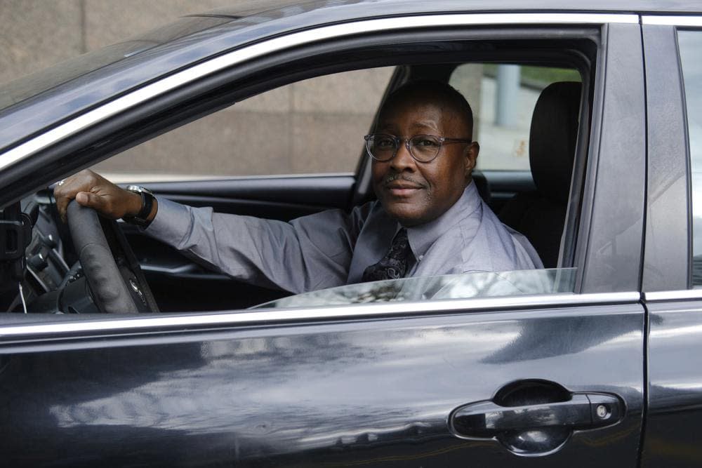 Pastor Kenneth Drayton of Mantels of Promise Ministries sits for a portrait inside his car in New York on Tuesday, Nov. 15, 2022. “You don’t always have to go to a church or sanctuary to experience the restoration and the power of God,” said Drayton, 61, an ordained minister who also drives part-time for for a ride-hailing service. (AP Photo/Luis Andres Henao)