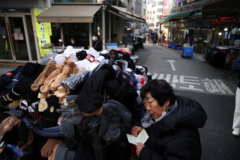 A stall-keeper works amid the COVID-19 pandemic at an empty shopping district in Seoul