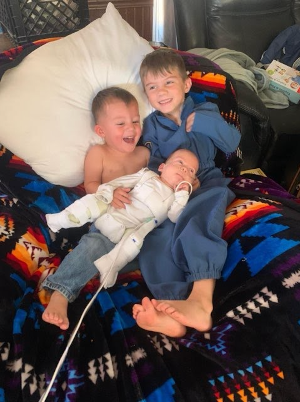 Adrian Torrez, 5, (left) and Mathias Torrez, 22 months, (right) shown holding their baby brother, Emilio Torrez, who has myelomeningocele spina bifida.