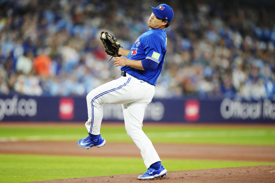 Toronto Blue Jays starting pitcher Hyun Jin Ryu (99) fields a ball off the bat of Cleveland Guardians' Kole Calhoun during the first inning of a baseball game in Toronto on Saturday, Aug. 26, 2023. (Frank Gunn/The Canadian Press via AP)