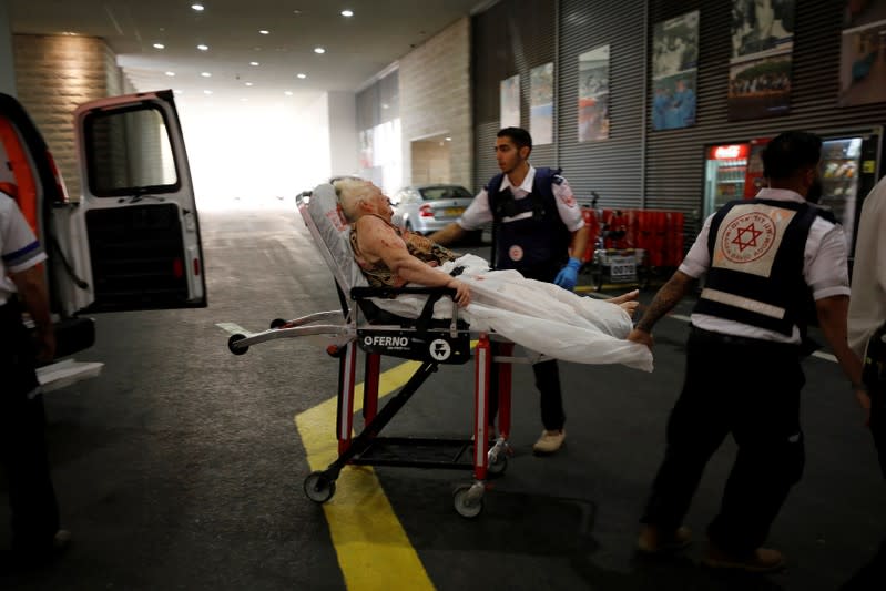 An injured woman is evacuated to hospital after a rocket was fired from Gaza into Israel, in Ashkelon, southern Israel