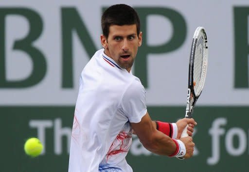 Novak Djokovic of Serbia returns a shot to John Isner of USA during their men's singles semifinal match at the BNP Paribas Open tennis tournament in Indian Wells, California. Isner defeat Djokovic 7-6(7), 3-6, 7-6(5)