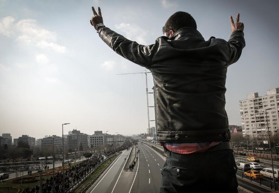 A man flashes a V-sign as thousands of people march for Berkin Elvan, a Turkish teenager who was in a coma since being hit on the head by a tear gas canister fired by police during anti-government protests in the summer of 2013, during his funeral in Istanbul, Turkey, Wednesday, March 12, 2014. On Wednesday, thousands converged in front of a house of worship calling for Prime Minister Recep Tayyip Erdogan to resign. (AP Photo/Emrah Gurel)