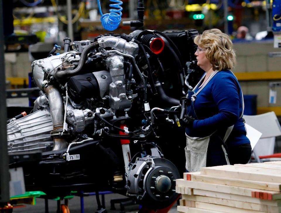 Line workers are pictured working on the chassis of full-size General Motors pickup trucks at the Flint Assembly plant in Flint, Michigan.