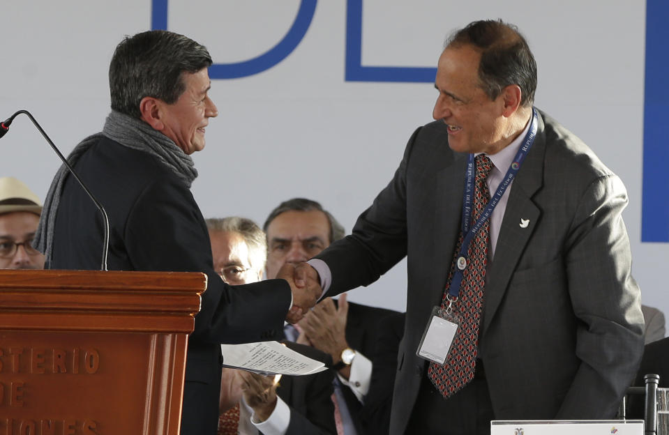 Colombia's government representative Juan Camilo Restrepo, right, shakes hands with National Liberation Army (ELN) representative Pablo Beltran during a ceremony marking the start of formal peace talks in Quito, Ecuador, Tuesday, Feb. 7, 2017. (AP Photo/Dolores Ochoa)