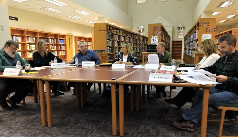 Members of the West Holmes school board look on as Treasurer Jamie Mullet, at left, gives her report.