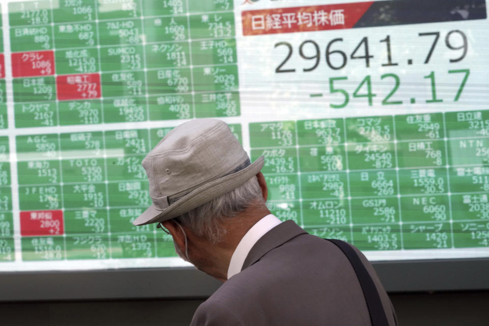 A man wearing a protective mask looks at an electronic stock board showing Japan's Nikkei 225 index at a securities firm Wednesday, Sept. 29, 2021, in Tokyo. Asian shares fell sharply on Wednesday after a broad slide on Wall Street as investors reacted to a surge in U.S. government bond yields. (AP Photo/Eugene Hoshiko)