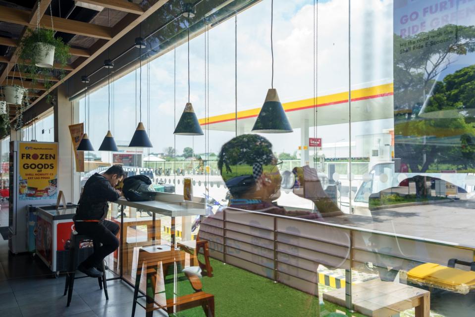 Customers rest at the food section of a Pilipinas Shell Petroleum Corp. gas station in Las Pinas, the Philippines, on Wednesday, Sept. 7, 2022. Pilipinas Shell plans to have retail shops and restaurants in a third of its gasoline refilling stations by 2025 as its seeks to boost revenues beyond fuel.