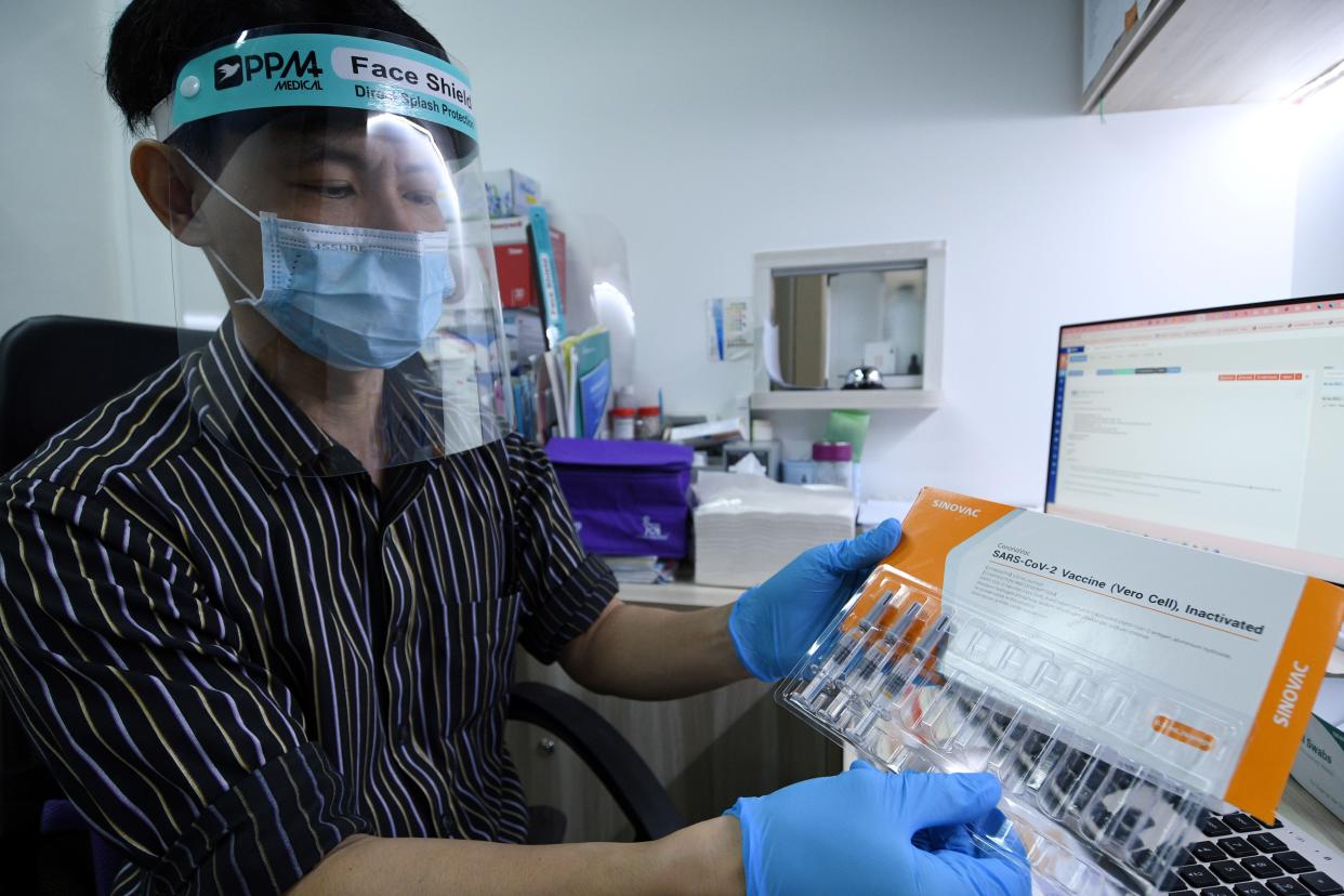 A doctor shows a box of Sinovac COVID-19 vaccines at a private clinic in Singapore on July 6, 2021. (Photo by Then Chih Wey/Xinhua via Getty Images)