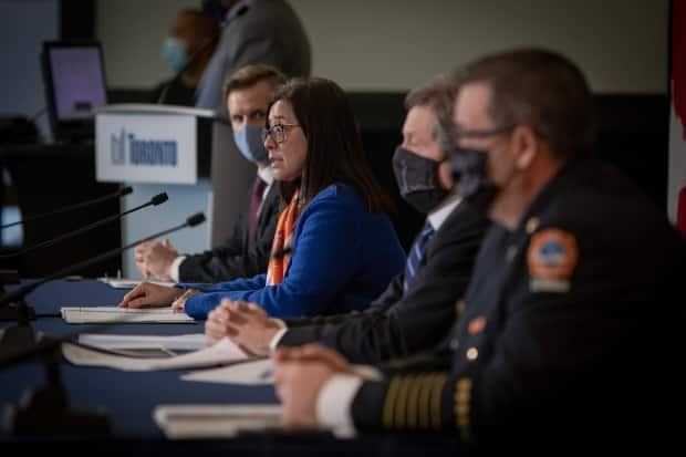 Mayor John Tory and Chief Medical Officer Dr. Eileen de Villa speak to reporters. A new report authored by de Villa suggests Toronto could see 2,500 new COVID-19 cases a day by the end of the month. (Evan Mitsui/CBC - image credit)