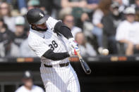 Chicago White Sox's Luis Robert Jr. hits a two-run home run off Detroit Tigers starting pitcher Kenta Maeda, Robert Jr.'s second of the game off Maeda, during the third inning of a baseball game Saturday, March 30, 2024, in Chicago. Yoan Moncada also scored on the play. (AP Photo/Charles Rex Arbogast)