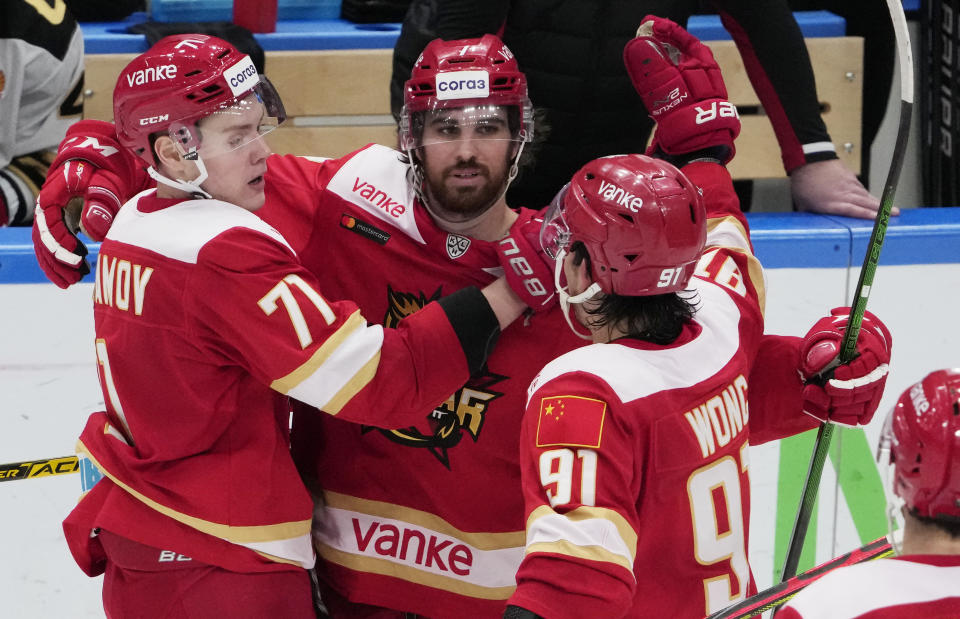 Kunlun Red Star's Jake Chellos, center, celebrates with teammates after scoring his side's first goal during the Kontinental Hockey League ice hockey match between Kunlun Red Star Beijing and Avangard Omsk in Mytishchi, outside Moscow, Russia, Wednesday, Nov. 17, 2021. (AP Photo/Pavel Golovkin)