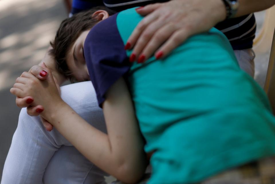 Tanya is comforted by a member of staff at the Odesa orphanage (Reuters)