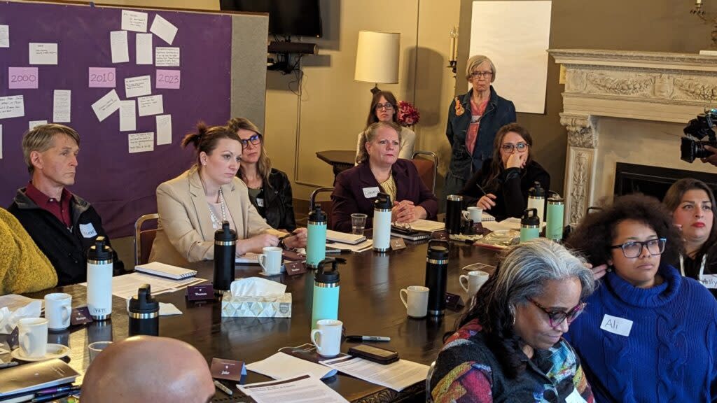 people sit around a table as they discuss and debate abortion rights