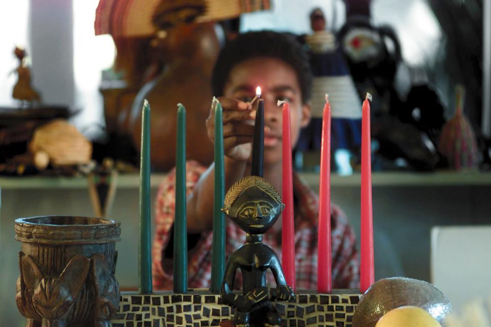 Aziza Amanuel, 13, a student at Whale Branch Middle School in Beaufort, S.C., lights a candle on the kinara Wednesday, Dec. 26, 2001 on the first night of Kwanzaa. (AP Photo/The Beaufort Gazette, Sue Jarrett) ORG XMIT: SCBEA 101