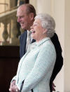 FILE - Britain's Queen Elizabeth II and Prince Phillip laugh as President Alexandre Kwasniewski of Poland and his wife Jolanta Kwasniewska leave Buckingham Palace in London, Friday May 7, 2004, after an official two day state visit to the United Kingdom. Caulkin, a retired Associated Press photographer has died. He was 77 and suffered from cancer. Known for being in the right place at the right time with the right lens, the London-based Caulkin covered everything from the conflict in Northern Ireland to the Rolling Stones and Britain’s royal family during a career that spanned four decades. (AP Photo/Dave Caulkin, File)