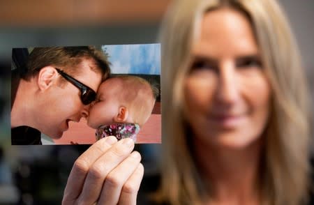 Kelly Pfaff holds a picture of her husband John and his daughter during an interview at her home in Park City