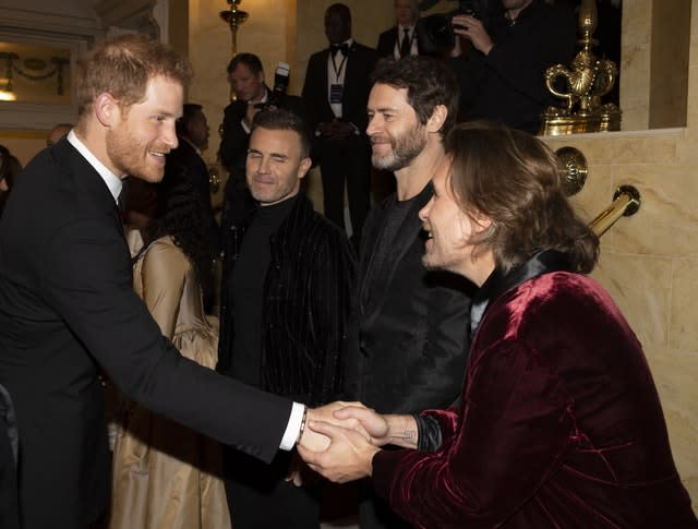 Harry shakes hands with Mark Owen of Take That