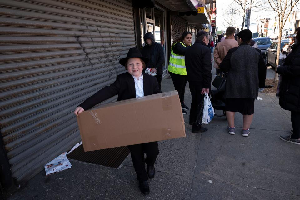 A boy carries a box of matzos for Passover that he picked up from his synagogue in the Brooklyn borough of New York. Amid the COVID-19 coronavirus outbreak, Jewish communities where the holiday of Passover is celebrated with a traditional meal known as a seder are  adapting their traditional rhythm of extended families dining and observing together.