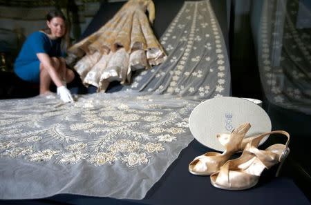 Curator Caroline de Guitar poses for photographers next to the wedding dress worn by Britain's Queen Elizabeth in 1947, ahead of the opening of an exhibition entitled 'Fashioning a Reign: 90 Years of Style from the Queen's Wardrobe', at Buckingham Palace, in London, Britain July 21, 2016. REUTERS/Peter Nicholls