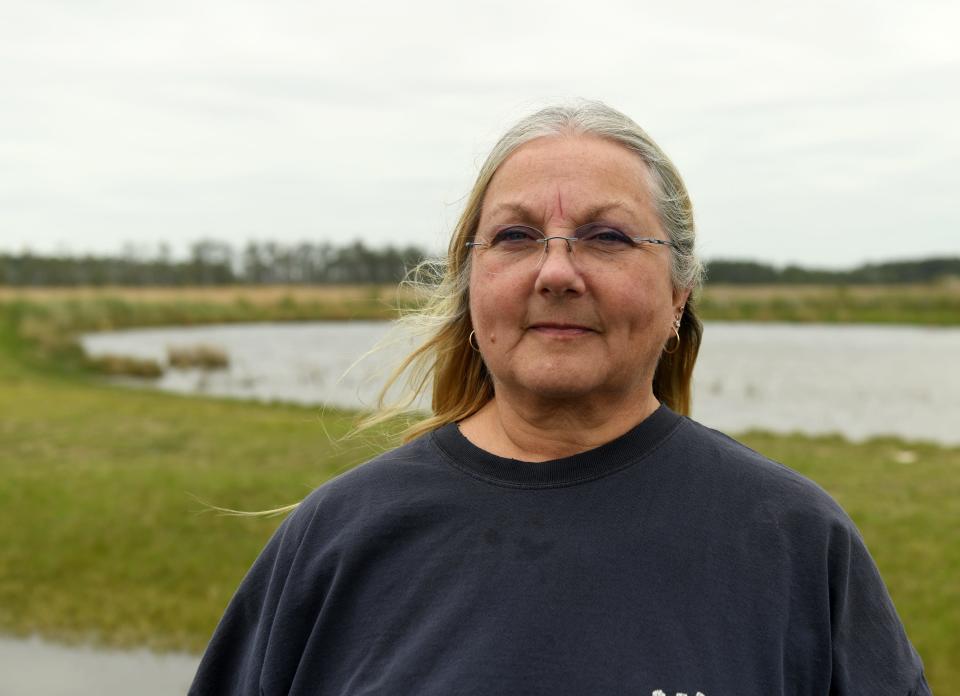 Chief Donna Abbott poses beside the marsh in lower Dorchester County, Maryland, on May 11, 2022. The Nause Waiwash, a small indigenous band on the Eastern Shore of Maryland, is grappling with low participation and a rapidly changing environment. Today its ancestral lands, nestled against the Chesapeake Bay, are sinking.