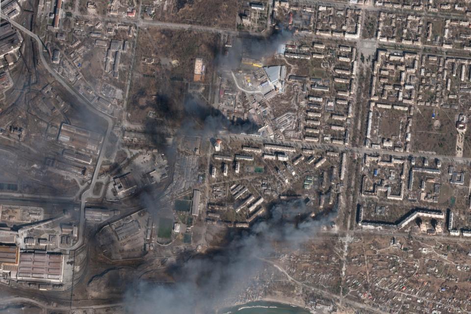 In this satellite photo from Planet Labs PBC, multiple civilian buildings burn on Sunday amid Russian strikes on the Livoberezhnyi District of Mariupol, Ukraine.