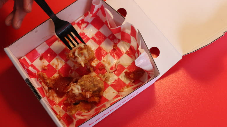 half-eaten chizza with plastic fork