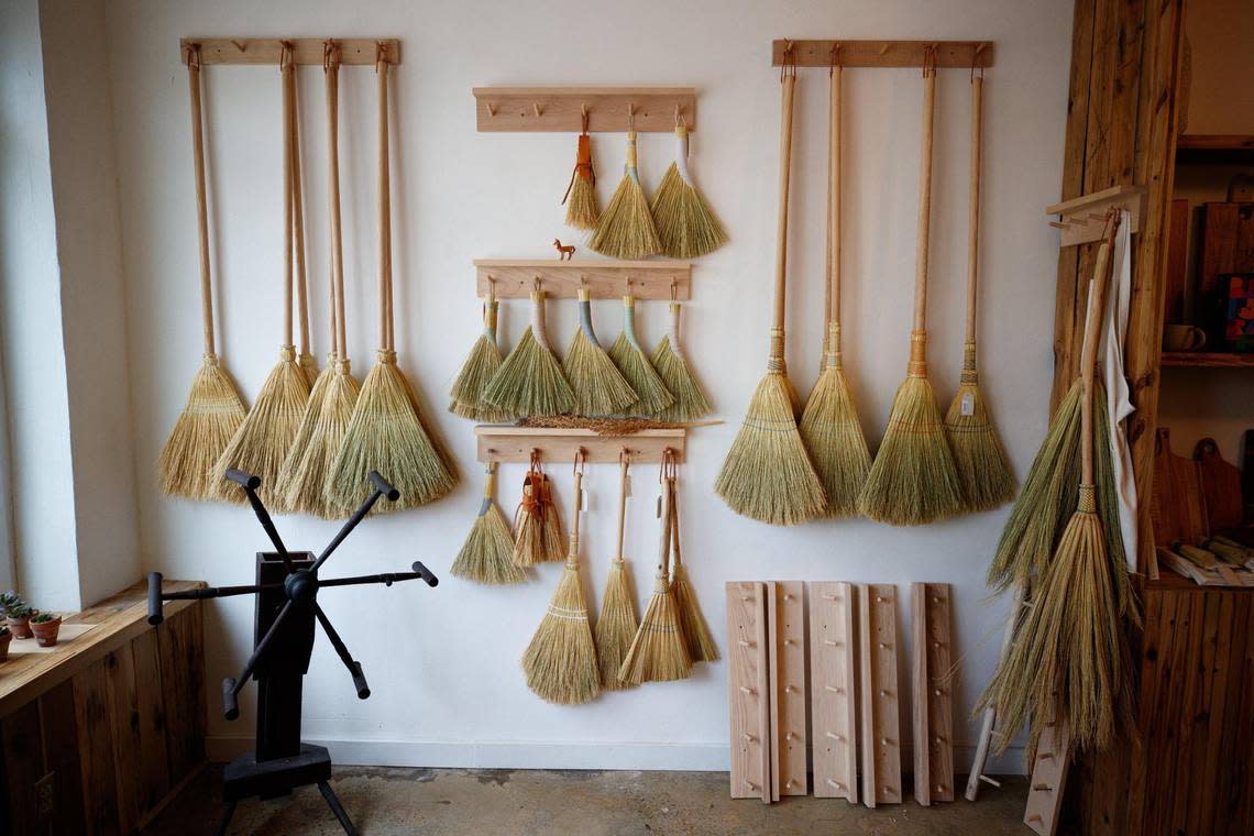Handmade brooms by Cynthia Main hang on display on Saturday, June 25, 2022, at Sunhouse Craft in Berea.