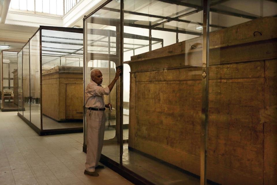 In this Wednesday, Oct. 30, 2013 photo, a workers cleans a glass case in the Egyptian Museum near Tahrir Square in Cairo, Egypt. The 111-year-old museum, a treasure trove of pharaonic antiquities, has long been one of the centerpieces of tourism to Egypt. But the constant instability since the 2011 uprising that toppled autocrat Hosni Mubarak has dried up tourism to the country, slashing a key source of revenue. Moreover, political backbiting and attempts to stop corruption have had a knock-on effect of bringing a de facto ban on sending antiquities on tours to museums abroad, cutting off what was once a major source of funding for the museum. (AP Photo/Nariman El-Mofty)