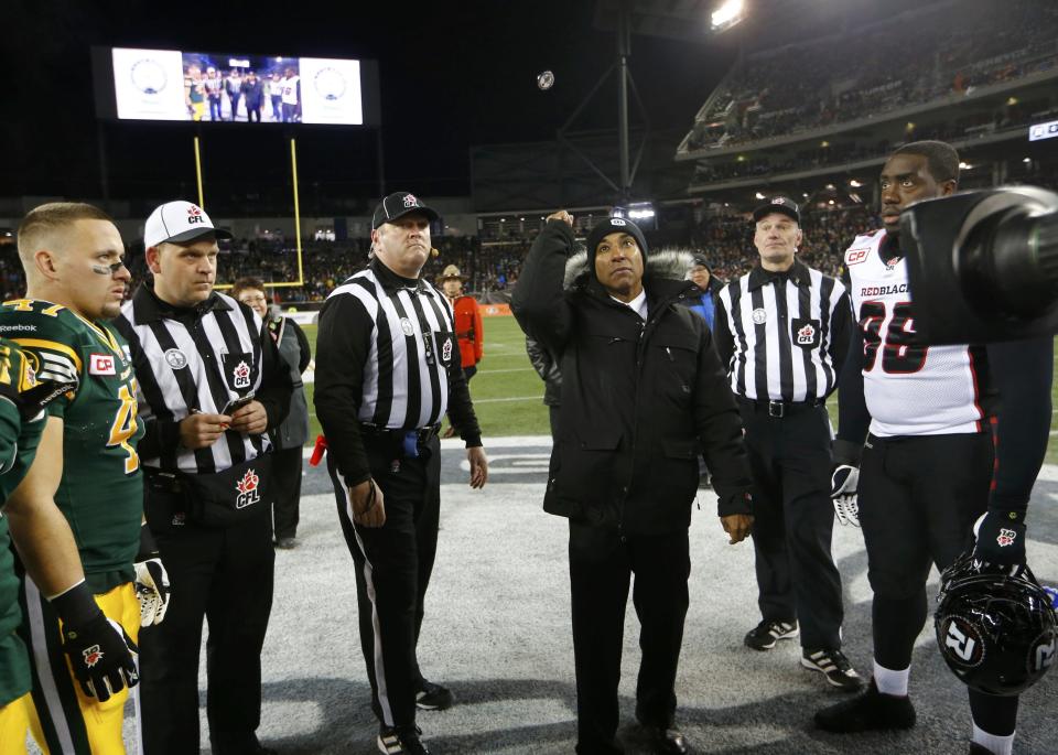 CFL commisssioner Jeffrey Orridge (C) throws the coin toss prior to the CFL's 103rd Grey Cup championship football game between the Ottawa Redblacks and the Edmonton Eskimos in Winnipeg, Manitoba, November 29, 2015. REUTERS/Mark Blinch