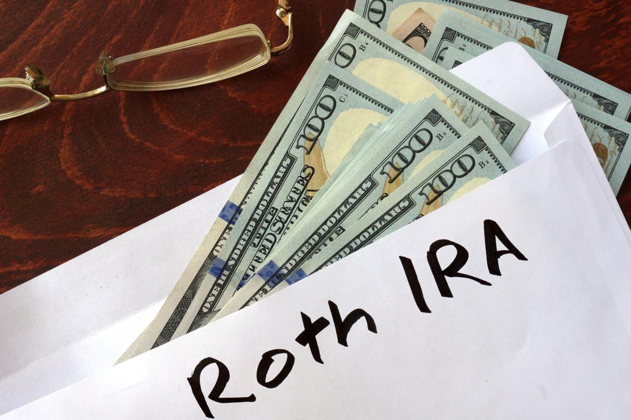 Roth IRA written on an envelope with dollars. Savings concept.