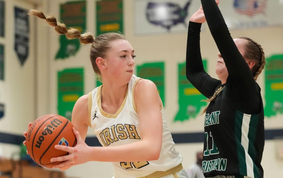 Cathedral Fighting Irish forward Taylor Lewis (32) rushes past Covenant Christian Jenna Rademacher (11) on Thursday, Jan. 11, 2024, during the City Tournament semifinals at Cathedral High School in Indianapolis. The Cathedral Fighting Irish defeated Covenant Christian, 39-32.