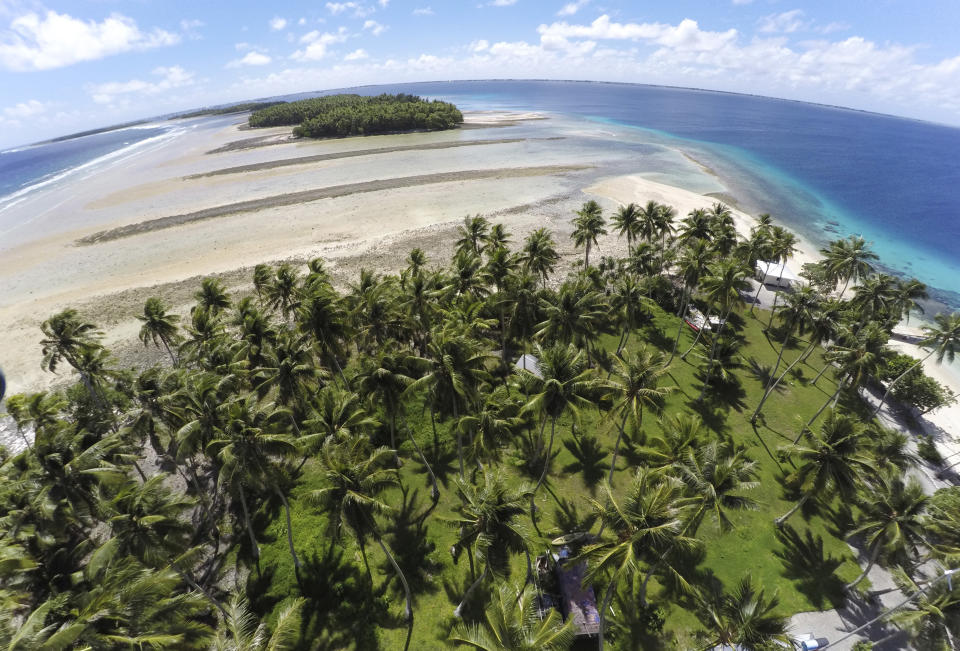 FILE - This Nov. 6, 2015, file photo, shows a large section of land between the trees washed away due to continuing rising sea leaves on Majuro Atoll, Marshall Islands. Small island nations are using the weeklong gathering of world leaders at this year’s U.N. General Assembly to highlight the one issue that threatens all of their existence: global warming. On the map, their homes are tiny specks in a vast sea of blue, rarely in the headlines and far removed from the centers of power. But for a few days each year, the leaders of small island nations share the same podium as presidents and prime ministers from the world’s most powerful nations, and their message is clear: global warming is already changing our lives, and it will change yours too. (AP Photo/Rob Griffith, File)