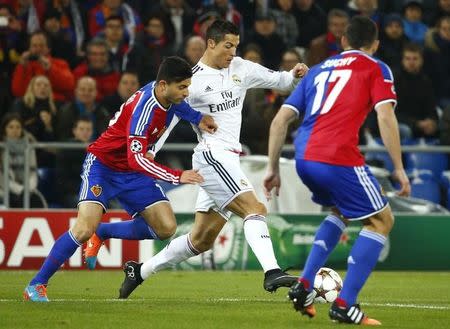 FC Basel's Behrang Safari (L) fights for the ball with Real Madrid's Cristiano Ronaldo during their Champions League Group B soccer match at St. Jakob-Park stadium in Basel November 26, 2014. REUTERS/Ruben Sprich