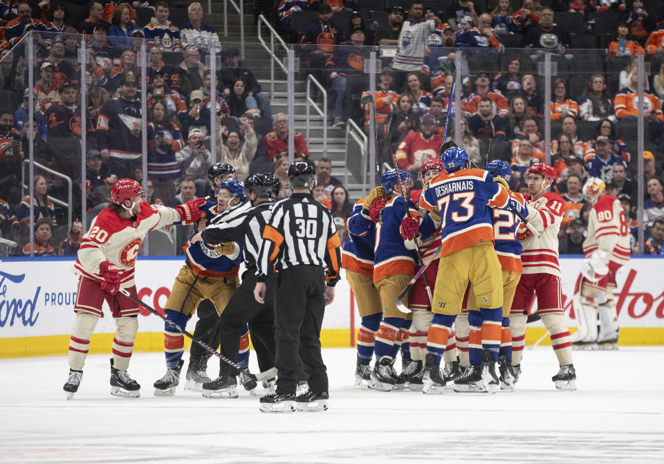 Calgary Flames and Edmonton Oilers players rough it up during the third period of an NHL hockey game Saturday, Feb. 24, 2024, in Edmonton, Alberta. (Jason Franson/The Canadian Press via AP)