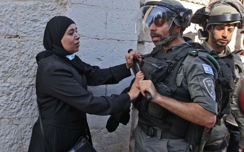 A Palestinian woman confronts Israeli security forces outside the Damascus gate in east Jerusalem, on June 15, 2021, ahead of the March of the Flags which celebrates the anniversary of Israel's 1967 occupation of the city's eastern sector. - Israel's new government faced an early test as Jewish ultranationalists prepared to march into annexed east Jerusalem, stoking tensions the UN has warned threaten a fragile Gaza ceasefire.  - AFP