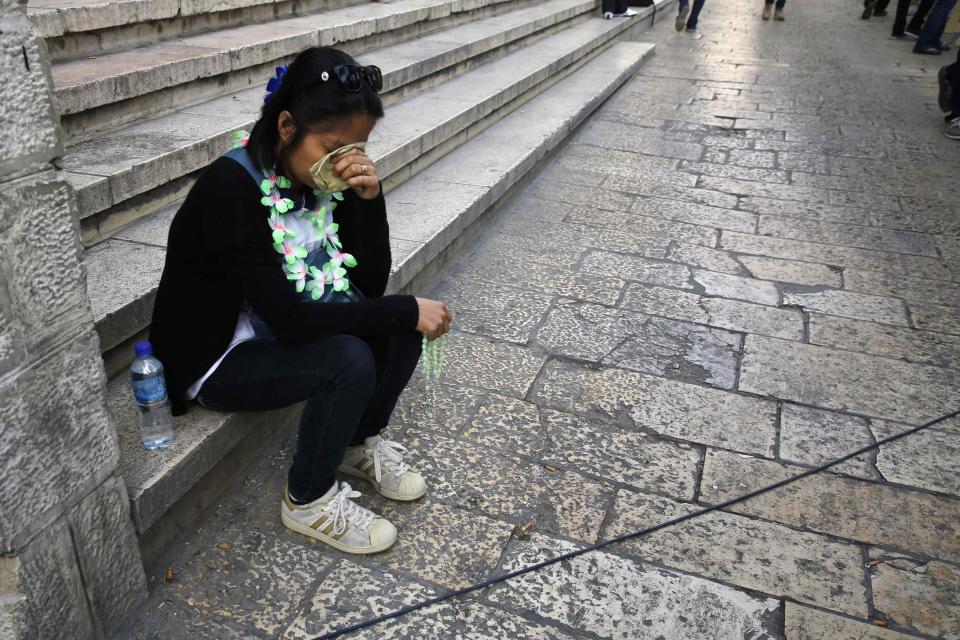 A woman prays as she awaits the arrival of Pope Francis at Manger Square