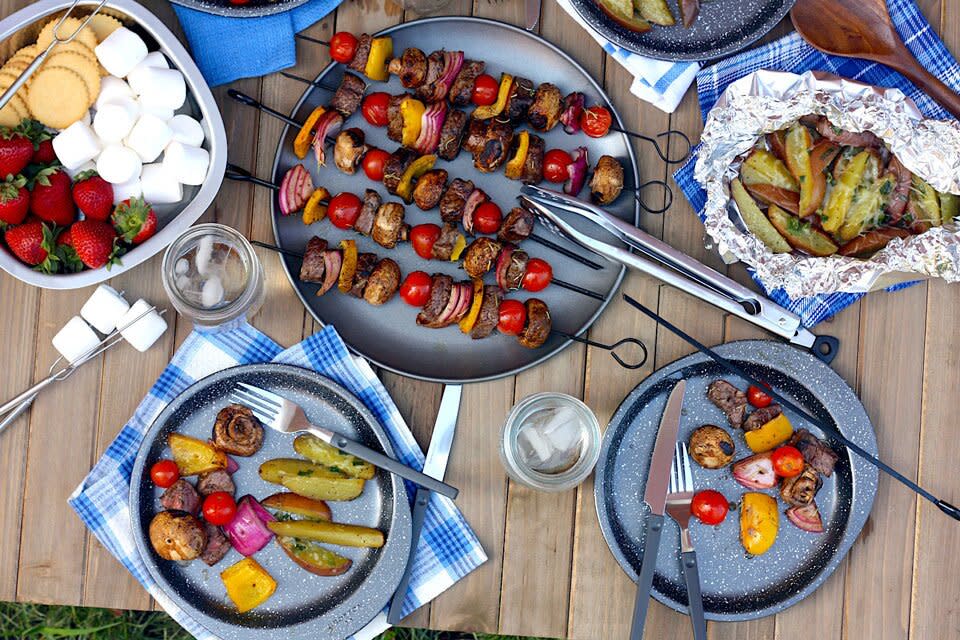 camp dinner with kebabs, cheesy potato packets and s'mores