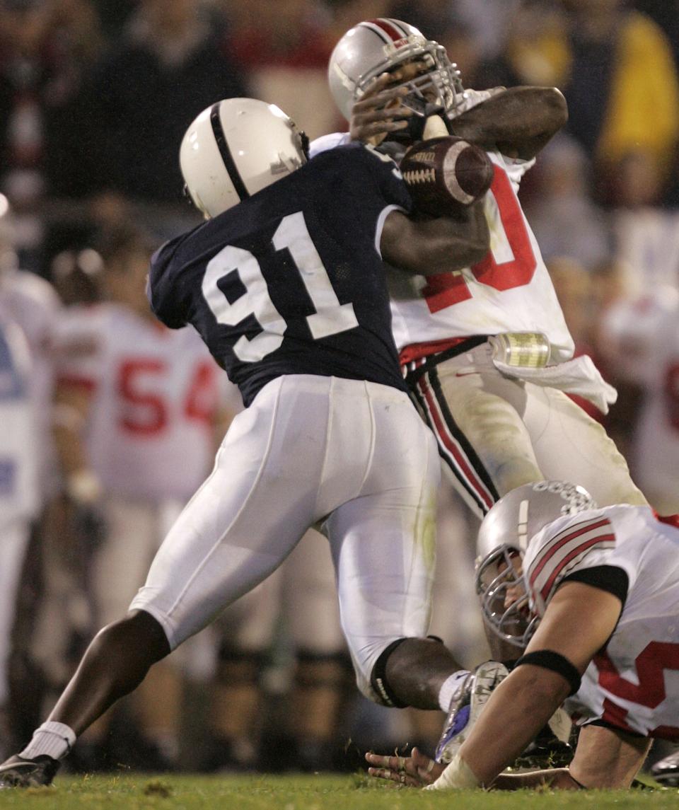Ohio State quarterback Troy Smith, right, fumbles the ball as he is sacked by Penn State defensive end Tamba Hali, left, during the last minutes of the fourth quarter in this Saturday Oct. 8, 2005, file photo in State College, Pa. Penn State won, 17-10. (AP Photo/Carolyn Kaster)