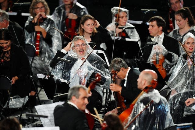 Musicians from the French National Orchestra shelter from the rain 